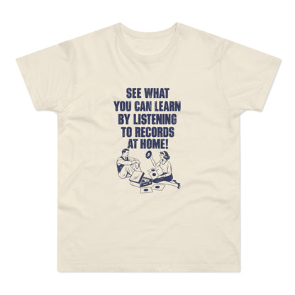 Cream-colored t-shirt featuring blue vintage-style text reading "SEE WHAT YOU CAN LEARN BY LISTENING TO RECORDS AT HOME!" above an illustration of a man and woman surrounded by vinyl records.