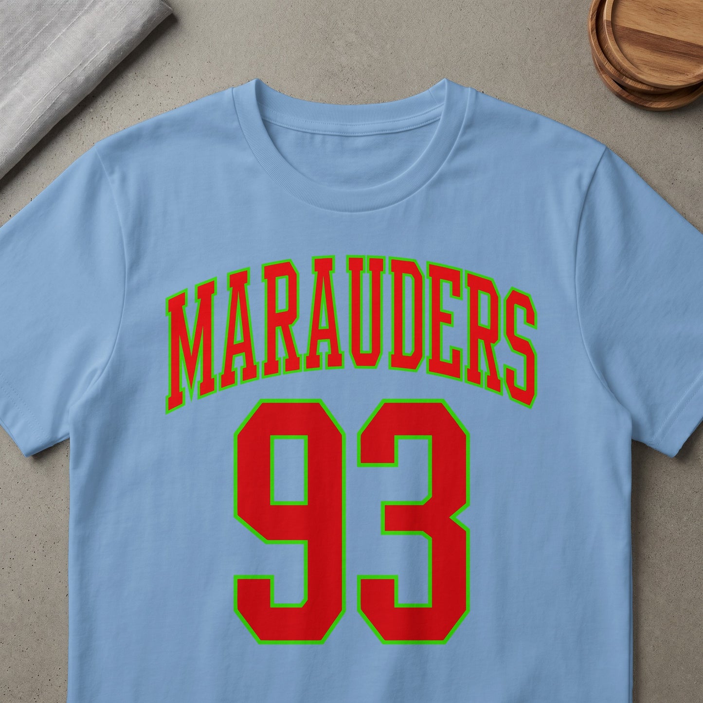 Light blue t-shirt with red text "Marauders 93" outlined in green.