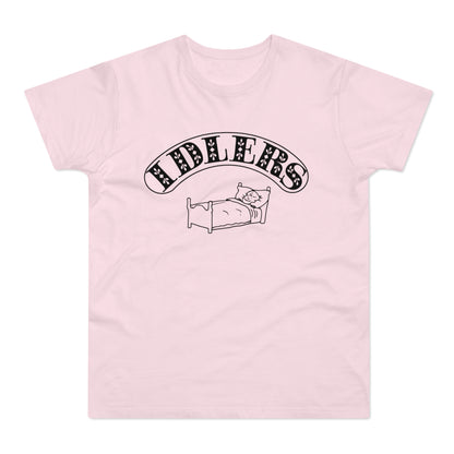 Pink t-shirt with black graphic of a person sleeping in a bed and the text "FIDLERS".
