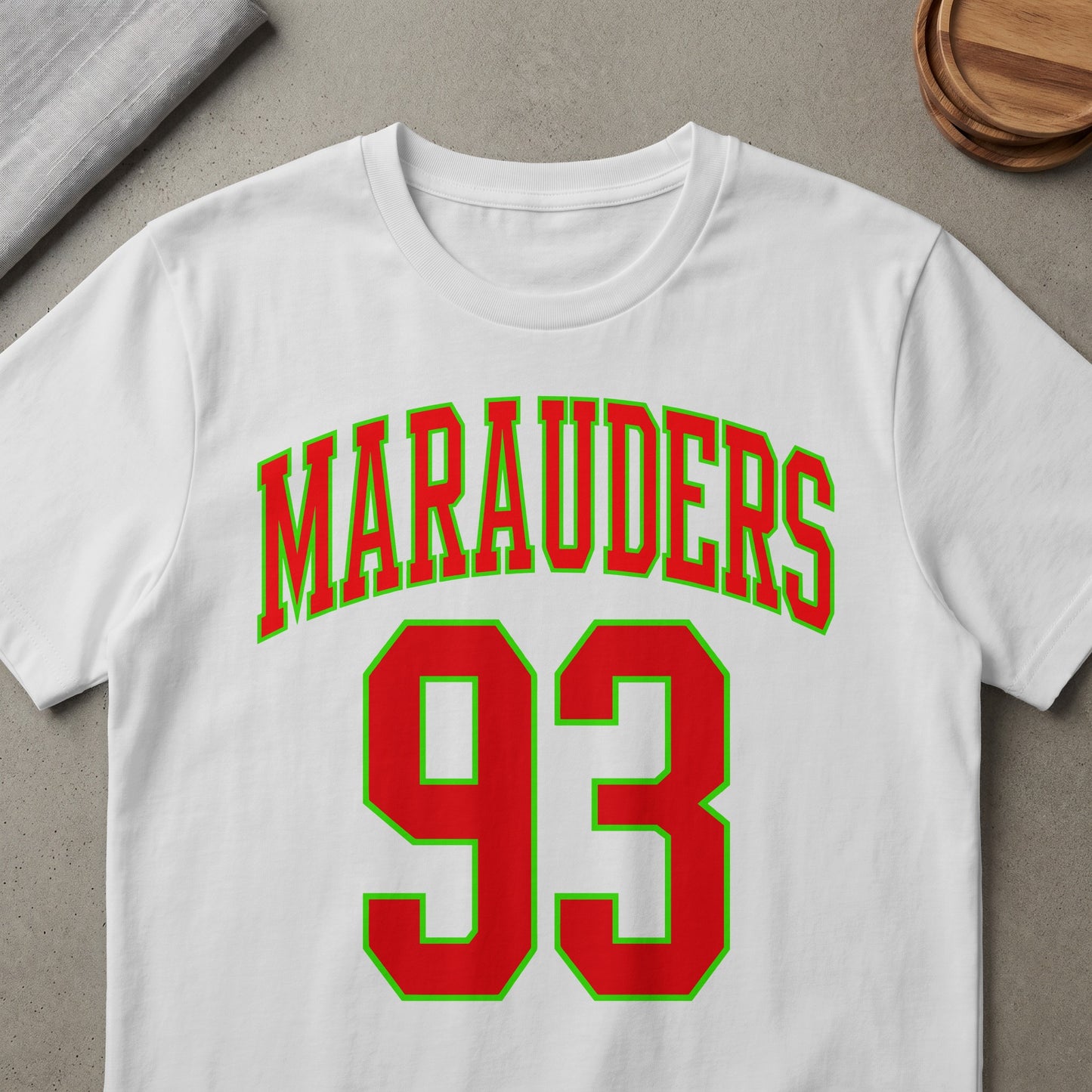 White t-shirt with red "Marauders" text and red number "93" bordered in green.