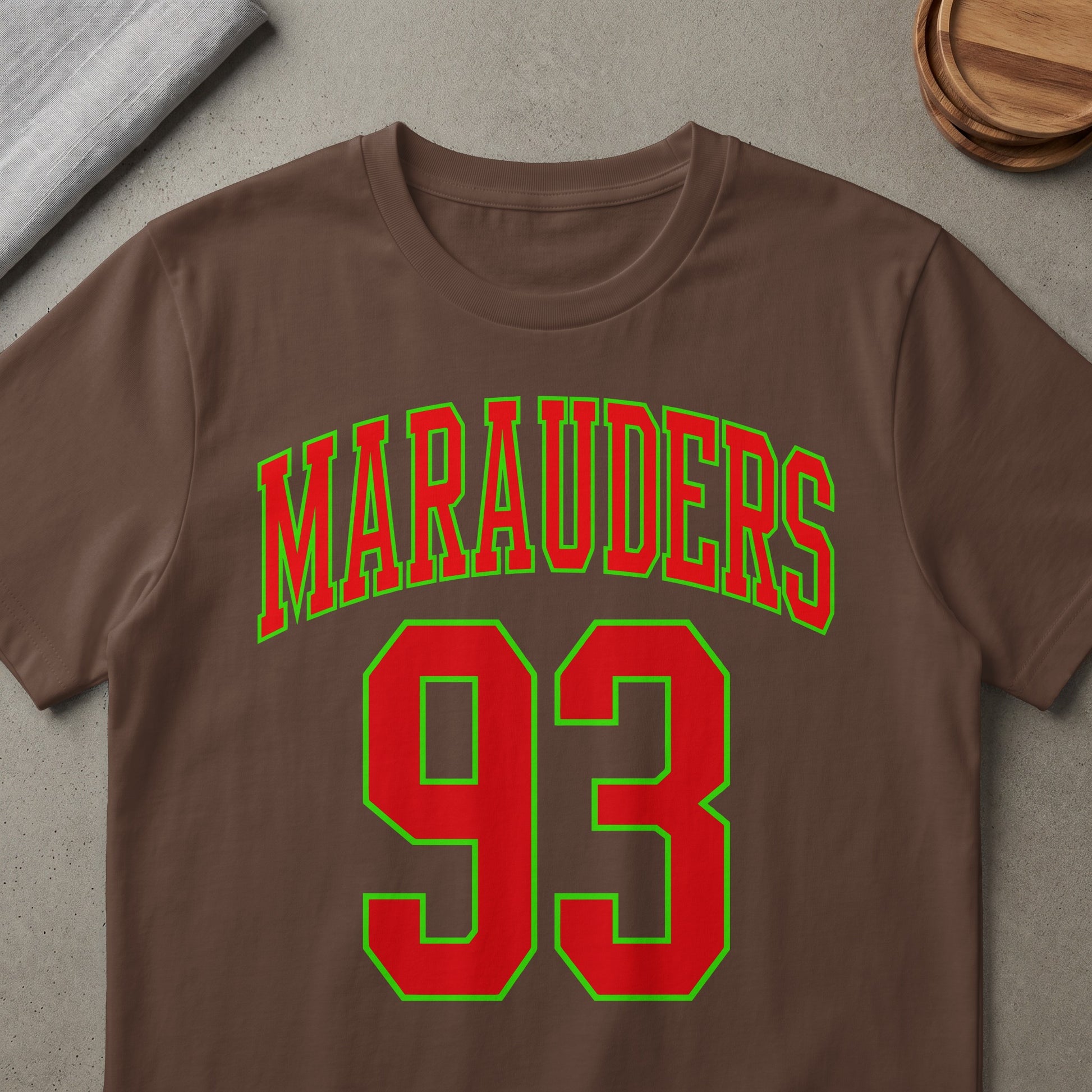 Brown t-shirt with red "Marauders 93" text outlined in green.