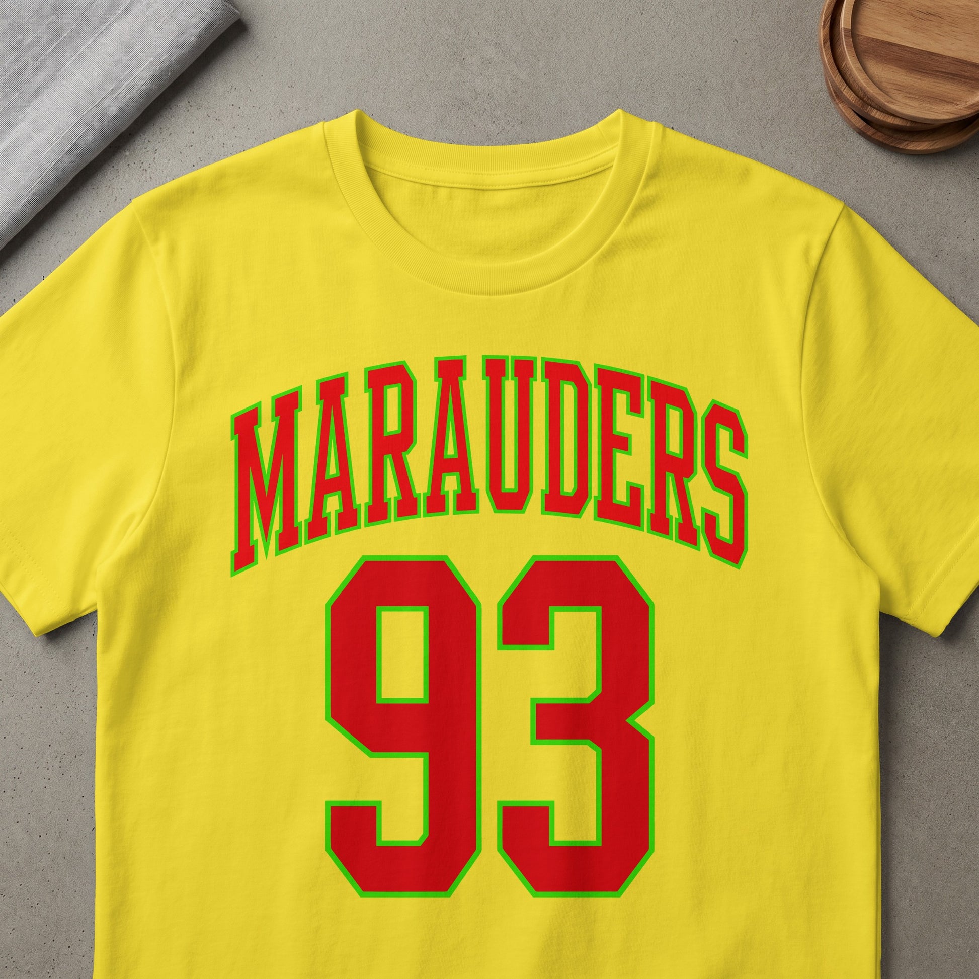 Yellow t-shirt with red and green "Marauders 93" text.